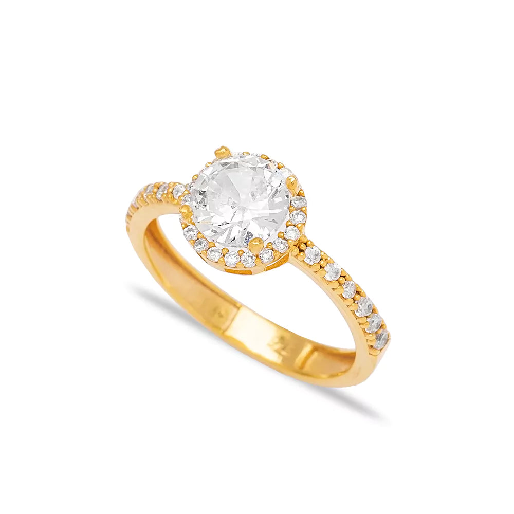 Sparkling gold-toned ring with a large central zirconia stone surrounded by a halo of smaller round diamonds, showcasing an elegant and luxurious design suitable for formal events.